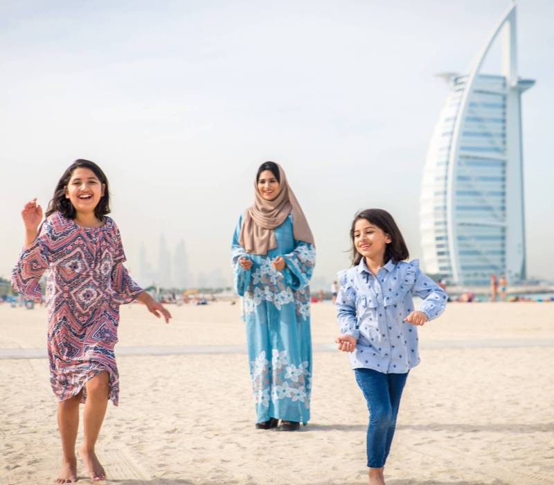 Happy arabian family having fun in Dubai - Mom together with her daughters on the beach